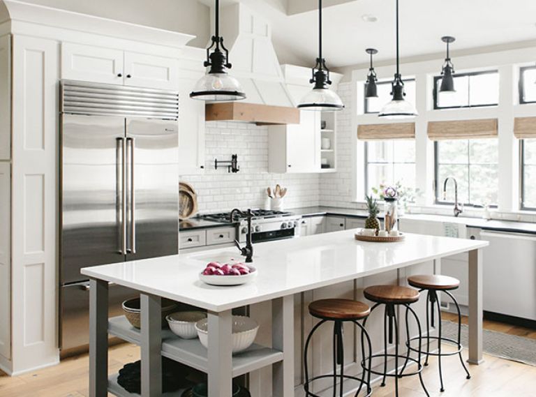 To counter the cool, white, grays and blacks, Gray added wood beyond the flooring, since it’s not at eye level. Wood-topped barstools draw the eye up to the windows and warm bamboo shades.