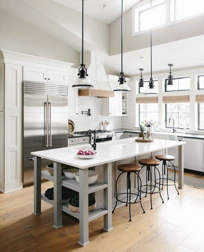 To counter the cool, white, grays and blacks, Gray added wood beyond the flooring, since it’s not at eye level. Wood-topped barstools draw the eye up to the windows and warm bamboo shades.