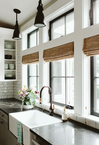 White farmhouse sink pops against surrounding Java Noir quartz countertops. Bronze Waterstone faucet adds warmth to the mix.