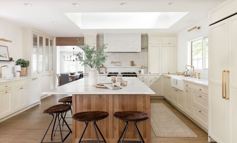 Interior designer Geneva Ness remodeled her Woodway, Washington home to be both elegant, and a cozy refuge for her family. The new kitchen has creamy Shaker-style cabinetry and brass accents, including pulls from House of Antique Hardware, an unlacquered brass kitchen faucet by Kallista, and picture lights found at Visual Comfort. Reggie counter stools from McGee & Co. offer striking contrast – and a place for the family to gather.