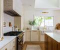 Zellige tile from Cle wraps the stove hood and backsplash behind the LaCornue range, while McGee & Co’s Persian-style runner leads to a Fireclay farmhouse-style sink tucked under the windows.