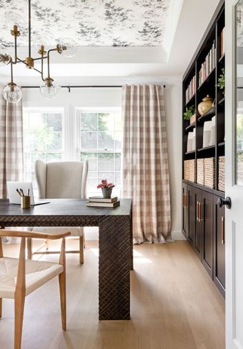 In the office, Anthropologie wallpaper on the ceiling is an unexpected accent over a desk and chair from Restoration Hardware.