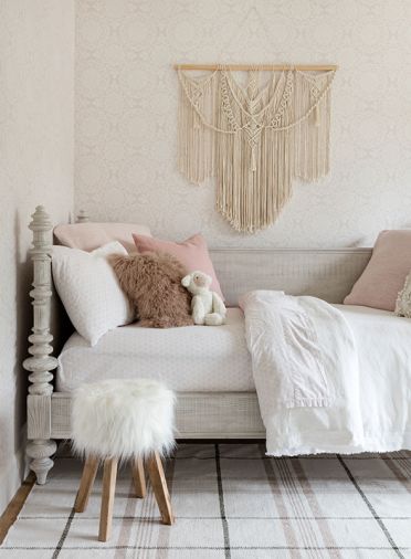 In her daughter’s en-suite, a Restoration Hardware vanity is topped with a Carrara marble counter and decked with a Kingston Brass faucet. Pale wallpaper from Wallpaper Direct surrounds the RH Teen bed, and pairs sweetly with a plaid McGee & Co rug. “I love wallpaper,” says Geneva. “I wanted to find as many places to use it as possible.” The macrame wall art is a thrift store score.