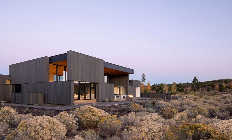 Corey Martin’s experience as a sculptor focused on making form inspired by the landscape contributed to his vision of creating architecture more intrinsically connected to Central Oregon’s unique geological landscape. Rooted in the surroundings of sagebrush below and endless skies above, Hacker Architects carved out this home as one whole from inside out. Dramatically stained Western Red Cedar on the exterior is naturally finished on interiors that extend from courtyard to kitchen. At far right is a small courtyard off the great room. An in-ground spa off the primary bedroom is sheltered by a louvered trellis above.