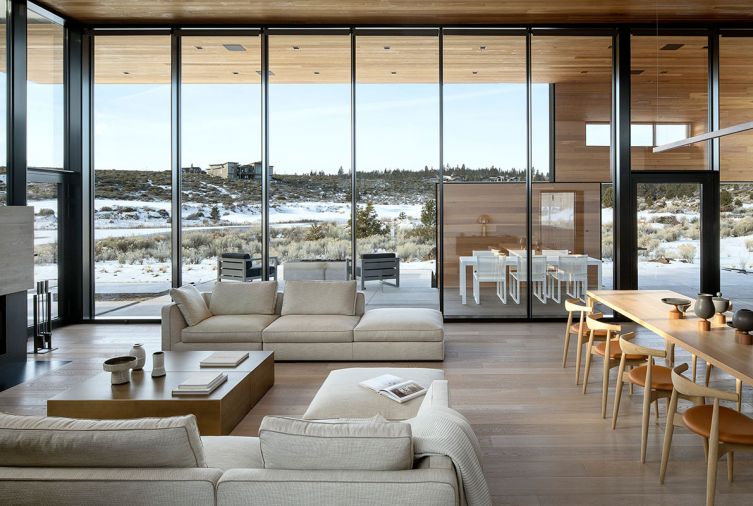 The view of snow-covered golf course is framed by house. “Buildings,” says Corey, “can break down their surroundings to connect people more directly to the landscape.” Glasbox windows rise to nearly 14 ft. Aluminum extrusion glass doors to 8 ft. Whitewashed wide plank engineered oak flooring with custom stain by Summers Flooring & Design. Mid-Century inspired furnishings selected by Hoffmans complete the “story” of their home.