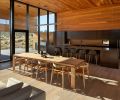 Natural stained cedar extends from the patio overhang to the interior ceiling, and frames the kitchen casework, doubling as the backsplash.