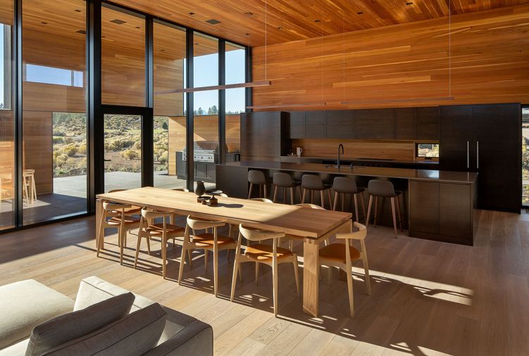 Natural stained cedar extends from the patio overhang to the interior ceiling, and frames the kitchen casework, doubling as the backsplash.