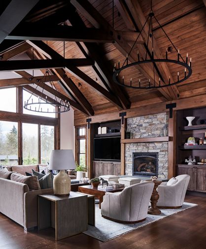 A pair of black iron Pearson chandeliers draw eye to superbly finished beams. Furnishings echo tones of El Dorado Stone fireplace with CR Laine Lincoln chairs in Winchester Vapor Leather and Adriana sectional atop wool Capel rug in Fog.