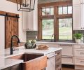 Thompson Traders hammered copper apron sink provides warmth against striking Ann Sacks profile beveled brick backsplash in Platinum Irid. Calcatta Natura Corian quartz countertop with Hansgrohe rubbed bronze faucet.