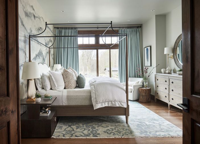 Auberge poster bed with metal canopy set against Phillip Jeffries wallpaper mimics soothing mountain range. Custom Belgian textured Linen 2-fold French-Pleat drapery in Spruce frames view. Slocum Hall side tables echo wood windows and doors.