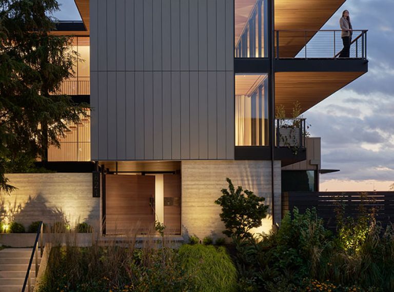 Pivot Cedar gate separates exterior from street. Deep cantilevered cedar eaves and roof provide protection from weather. Native plants, vine maples, dogwood, Oregon grape protect severe slopes.