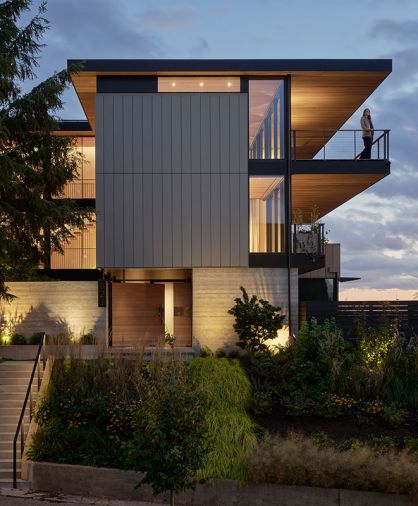 Pivot Cedar gate separates exterior from street. Deep cantilevered cedar eaves and roof provide protection from weather. Native plants, vine maples, dogwood, Oregon grape protect severe slopes.