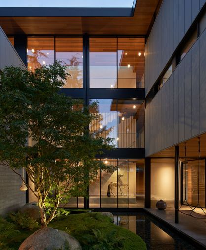 Structure is built around a central courtyard featuring Land Morphology’s lush plantings of Japanese Maple scolopendrifolium, baby tears ground cover, and handpicked boulders from Marenakos Rock Center as unique water feature. Three-story PanoramAH windows and doors reveal stacked staircases and vintage carousel horse. Custom walnut swings reach out over water.