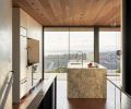 Venetian plaster stairwall on upper floor bridge connects East-facing roof deck and media room to West-facing great room. Island’s waterfall Bianco Treviso marble with Julien J7 sink and Brizo Litze articulating faucet. Bocci pendants. Walnut flooring grounds Western Red Cedar ceiling.