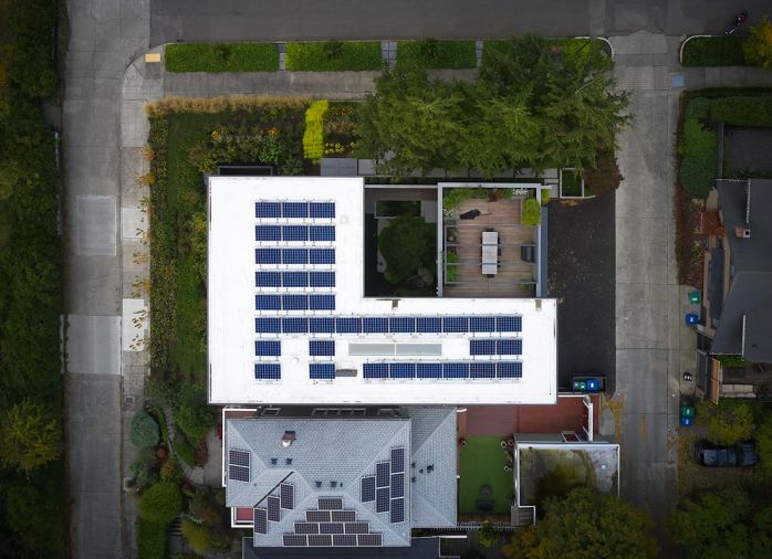Aerial view of property with photovoltaic solar array.