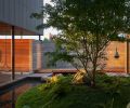 Land Morphology courtyard with split boulders, Japanese maple, and pond.