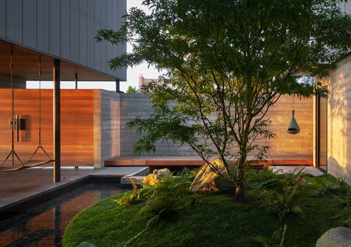 Land Morphology courtyard with split boulders, Japanese maple, and pond.