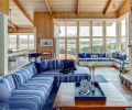 Bold, beachy stripes anchor the great room seating for cozy all season views. Original cedar work was preserved throughout, while the fireplace was replaced with a more place-appropriate river-rock façade with limestone hearth and mantle designed by Ann McCulloch Studio. Pillows, throw, and other accessories from Ann McCulloch Studio.