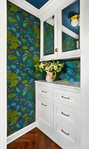 Watching homeowners struggle with uninsulated pantry inspired Arlene to create a new entry with drop-zone/phone-charging station trimmed in same Kravet wallpaper.