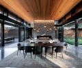 The homeowner’s love for Japanese architecture inspired Berry’s great room flanked by dual 35  Weiland Aluminum/Wood Liftslide doors from Portland Millwork and grounded by Island Stone split face silver quartzite fireplace. Biella Lighting Design.