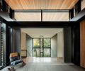 Entry foyer brings outside elements in with textured obsidian granite flooring. Berry introduces structural elements of steel, wood, stone + glass. Quentin lounge chair. Staircase down to “hidden floor.”