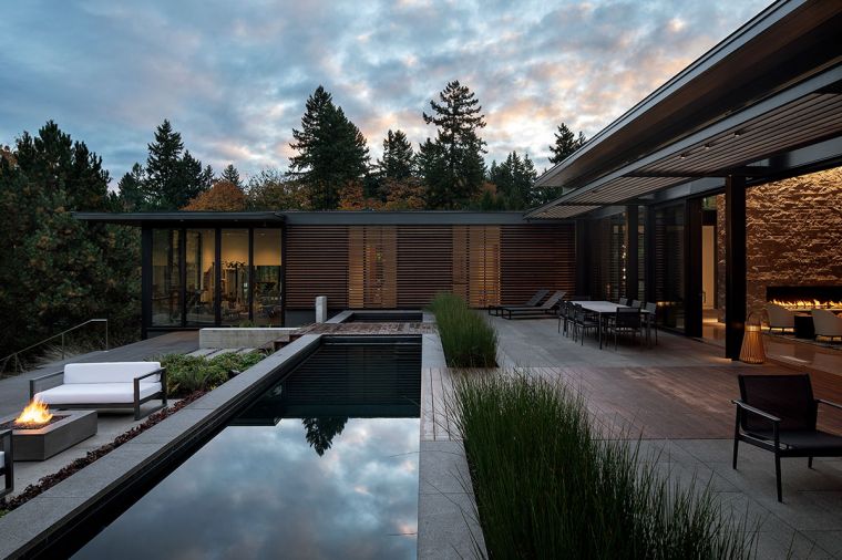 Thermory decking. Common Rush plantings create verticality alongside the lap pool whose darkened interior transform its still waters into a reflecting pool.