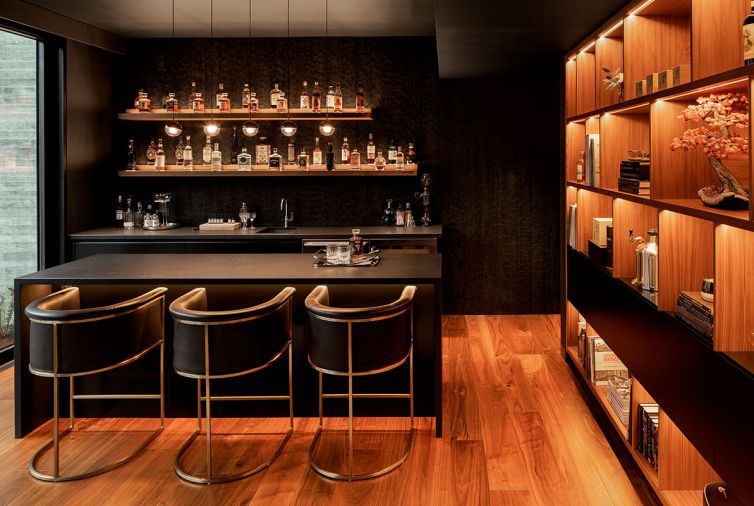The homeowner, a connoisseur of whiskeys collected from around the world, wanted to create a “hidden” speakeasy or Whiskey Room in the lower floor. An 800-pound faux bookcase disguises the entrance to the speakeasy, doubling as room’s door. Back wall features Japanese Art of charred Accoya Gator Shou Sugi Ban by Delta Millworks. Thomas Warner Wine Cellars design.