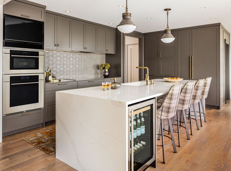 Dark cabinets don’t necessarily mean that your kitchen will be dark. Glossa customized the warm grey color – a hard-wearing conversion varnish by Morgan’s Fine Finishes. “With the lighter countertop and statement backsplash (“Akira” by Sonoma Tilemakers), the kitchen doesn’t feel too heavy. That’s the trick – where to bring in the light,” says Glossa.