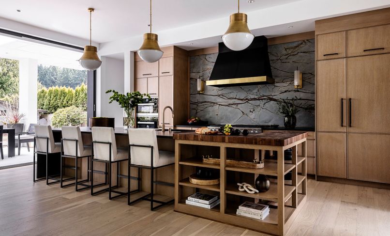 The “wow element” in the kitchen, says Kowalski, is the Pental quartzite slab, which covers the backsplash behind the stove, and is accented with a gorgeous black metal hood, with inset Vent-A-Hood, flanked by sconces from Arteriors. Brass accents, including a Brizo faucet and pendants by Circa Lighting, warm the space, alongside the walnut endgrain butcher block counter by Grothouse that wraps the end of the island.