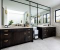 The vanity sports natural quartzite by Pental. The soaking tub has Newport Brass plumbing, and Arteriors wall sconces provide atmospheric lighting.