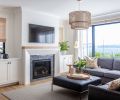 This cozy family room, outfitted with a sectional and ottoman from Lee Industries and DMI rug, is a favorite spot to sit and enjoy the views.