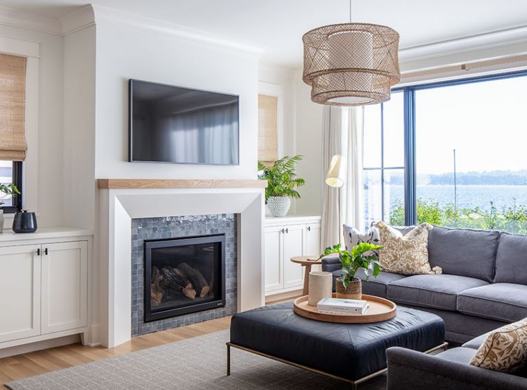 This cozy family room, outfitted with a sectional and ottoman from Lee Industries and DMI rug, is a favorite spot to sit and enjoy the views.