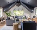 The dramatic vaulted ceiling in the bonus room is painted Benjamin Moore Baby Seal, and adorned with a light fixture from Visual Comfort. Stroud covered the Lee Industries sectional and chair with JAB fabric from the Dixon Group at the Seattle Design Center. The coffee table and side table are from Serena & Lily.