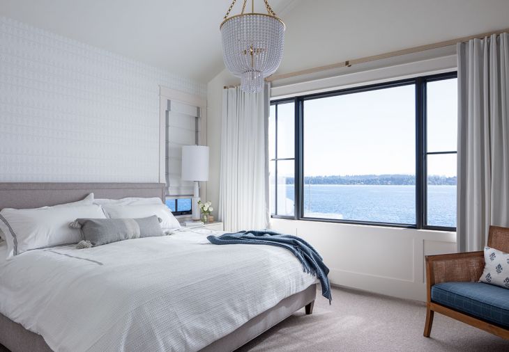 The main bedroom is softened with custom window coverings, including curtains composed of Pindler & Pindler linen fabric, and a shade with Schumacher trim from The Dixon Group.