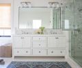 The main bathroom is now wrapped in 3x6 Calacatta marble tile by Ann Sacks, in a wainscot behind the Signature Hardware tub and vanity, and in the walk-in shower. The overhead and sconce lighting is by Visual Comfort. Stroud designed the vanity with Waterworks hardware.