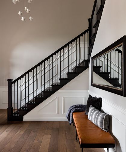 Stefanie and Lars Gouwerok’s Seattle home speaks to their style after a remodel led by interior designer Brooke Prince of the White Space Design Group. In the entry, a Bocci chandelier is suspended over a refreshed staircase and CB2 bench with Susan O’Conner pillows.