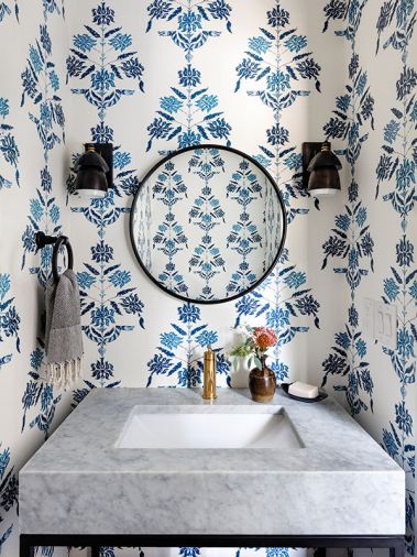 In the powder room, a Restoration Hardware console is accented with brass Kohler plumbing, and Circa Lighting sconces flank the mirror.