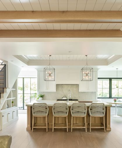 Atelier Drome designed kitchen layout with warm wood accents in beams and island. Tray ceiling with shiplap and crown molding painted Benjamin Moore Chantilly Lace. Hudson Valley metal caged lighting with farmhouse flare. Cabinetry built by Amish carpenters in Ohio. Pella windows.