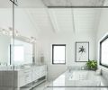 Seen from the shower, primary bath features vaulted ceiling and Jacuzzi tub with natural Carrera marble deck and counter by Noble Interiors & Design. Amish built double vanity with Water Street Hardware from Builders Hardware. Restoration Hardware vanity lighting.