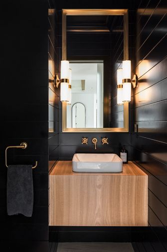 Dramatically designed Powder Room was Alison’s nod to 10 years of New York City living. She calls it, “A dark, moody, dramatic hotel type experience.” Real wood Tricorn Black Sherwin Williams painted paneling, flattering Restoration Hardware lighting. Solid Slab White Oak sink mount custom Amish-built design by Dacoda Homes.