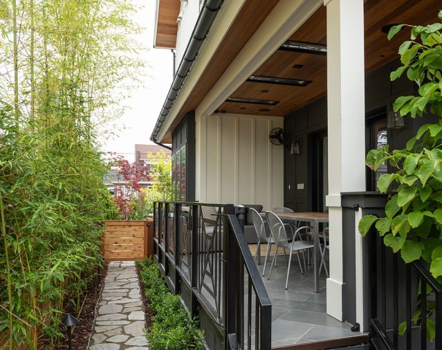 Back porch railing Dacoda Homes design. Three-panel Pella pocketed doors open outdoor living to add further spaciousness to central living areas. Room & Board furnishings. Infratech heaters in ceiling allow year-round indoor/outdoor Pacific Northwest living.