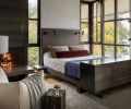 Steel fireplace in primary bedroom includes concrete hearth. Custom Geremia leather and steel bed co-designed with fabricator Todd Von Martens. Workstead floor lamp teams with vintage Pamono club chair.