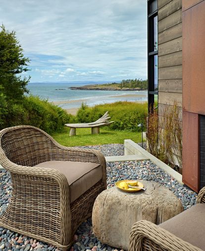 Low tide in False Bay toward Haro Strait and the Olympic Mountains. Existing driftwood bench. A masonry fireplace is overlayed with hot rolled steel that has weathered in the elements.