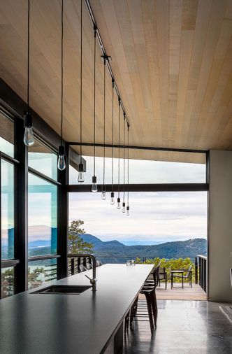 A 25-foot island anchors the kitchen and dining room. Pocketed sliding glass doors by Fleetwood frame the distant views and connect to the rear deck.