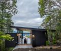 The upper level of the home has the main living spaces, storage, and a main suite, as well as front and rear decks. The lower level has an en-suite and a deck with views of the forested hillside. The landscaping was done by Steve Stanzione of Native Landscapes.