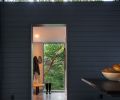 The mudroom and pantries are tucked behind a wall of clear cedar channel siding, and the floors are concrete.