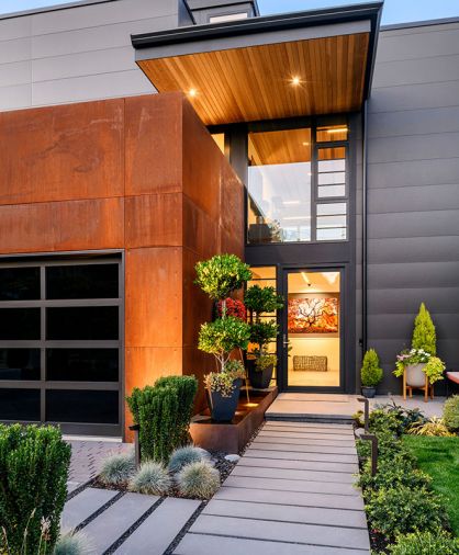 Williams’ use of horizontal garage glass echoes Marvin Contemporary windows’ placement and is reiterated in staircase tower’s glass orientation. Japanese Holly Sky Pencil pops against Corten steel garage.