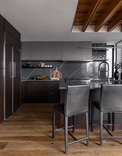 Kitchen features painted Sapele African hardwood upper cabinets by Sky River Industries. Thin Line Sonneman light fixture task lighting. Espresso-stained lower cabinets play off Hallmark Alta Vista Malibu wooden floors from CFM. Crate & Barrel leather stools.
