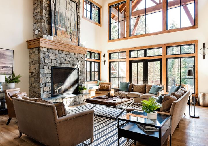 The living room is anchored by a large hearth clad in “Canyon Creek” stone by Mutual Materials. Black-framed Windsor Windows look crisp against wood casework and white oak floors, the “Rhine” from Wind River Flooring, sourced from Standard Floors. On the walls, Visual Comfort sconces from DFG at the Seattle Design Center are elegant accents. The seating area is composed of Lee Industries sofas and Four Hands coffee table atop an Annie Selke rug, all sourced from J Garner Home.