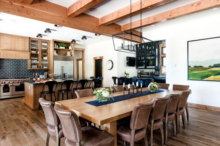 White Label Interiors custom designed the dining table, made by Winterwood Cabinets. The Four Hands dining chairs are from J Garner Home, and the iron light fixture overhead is Miseno.